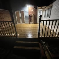 Illuminated timber decking and steps at night with feature lights