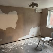 Room wall being stripped and prepared during an interior renovation project