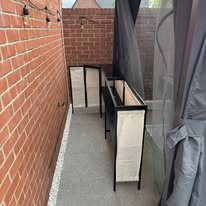 Two assembled outdoor storage cupboards fitted along a narrow side passage