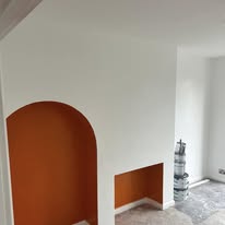 Room prepared for painting with arched alcoves and fresh white walls