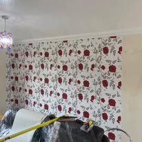 Red rose patterned wallpaper hung in an Aylesbury bedroom