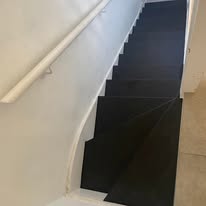 Finished black and white staircase viewed from above with neat edge detail