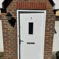 White front door repainted with glazed panel and house number seven