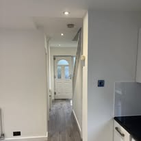 Freshly finished hallway leading to a white front door after renovation work