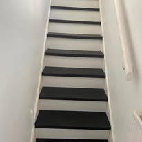 Black and white painted staircase with decorative wall panelling