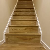 Completed light oak stair finish with clean white risers and neat edges