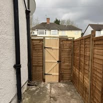 Wooden garden gate and fence panels fitted in a side alley