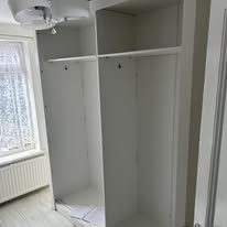 Open fitted wardrobe compartments with shelves and hanging rails ready for storage