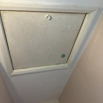 Closed loft hatch with pull handle fitted neatly into a ceiling