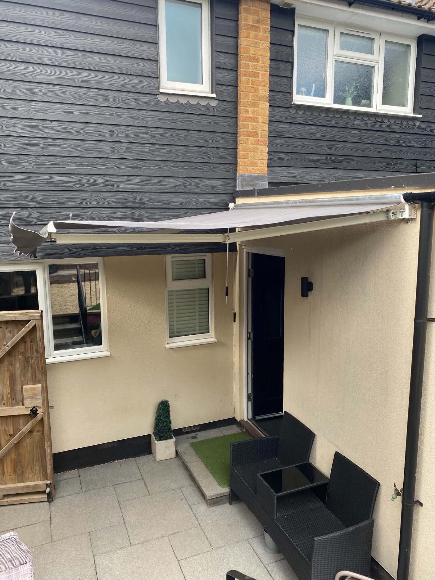 Grey retractable awning fitted above a patio door on a house in Aylesbury