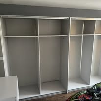 Large white wardrobe run with multiple shelves, compartments and drawers fitted inside