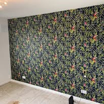 Dark floral geometric feature-wallpaper fitted across a full room wall