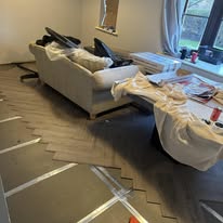 Living room floor preparation during a house renovation with dust sheets and tools