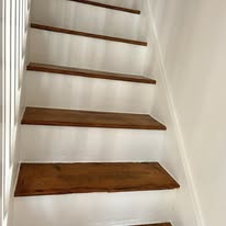 Finished stair area with white risers and warm timber detail after careful fitting