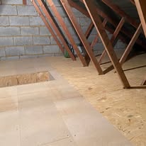 New loft floor boards fitted around a central access hatch opening