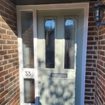 Light green front door with glazed panels after exterior door painting