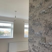 Neutral safari and animal print wallpaper hung in a bedroom corner