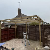 Timber pergola structure in a garden during the daytime