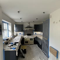 Kitchen and adjoining room protected with dust sheets during renovation preparation